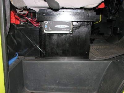 Assise du siège passager<br />Batterie AUX de 120A<br />Chargeur de batteries<br />A gauche, cric Hi-lift et son embase